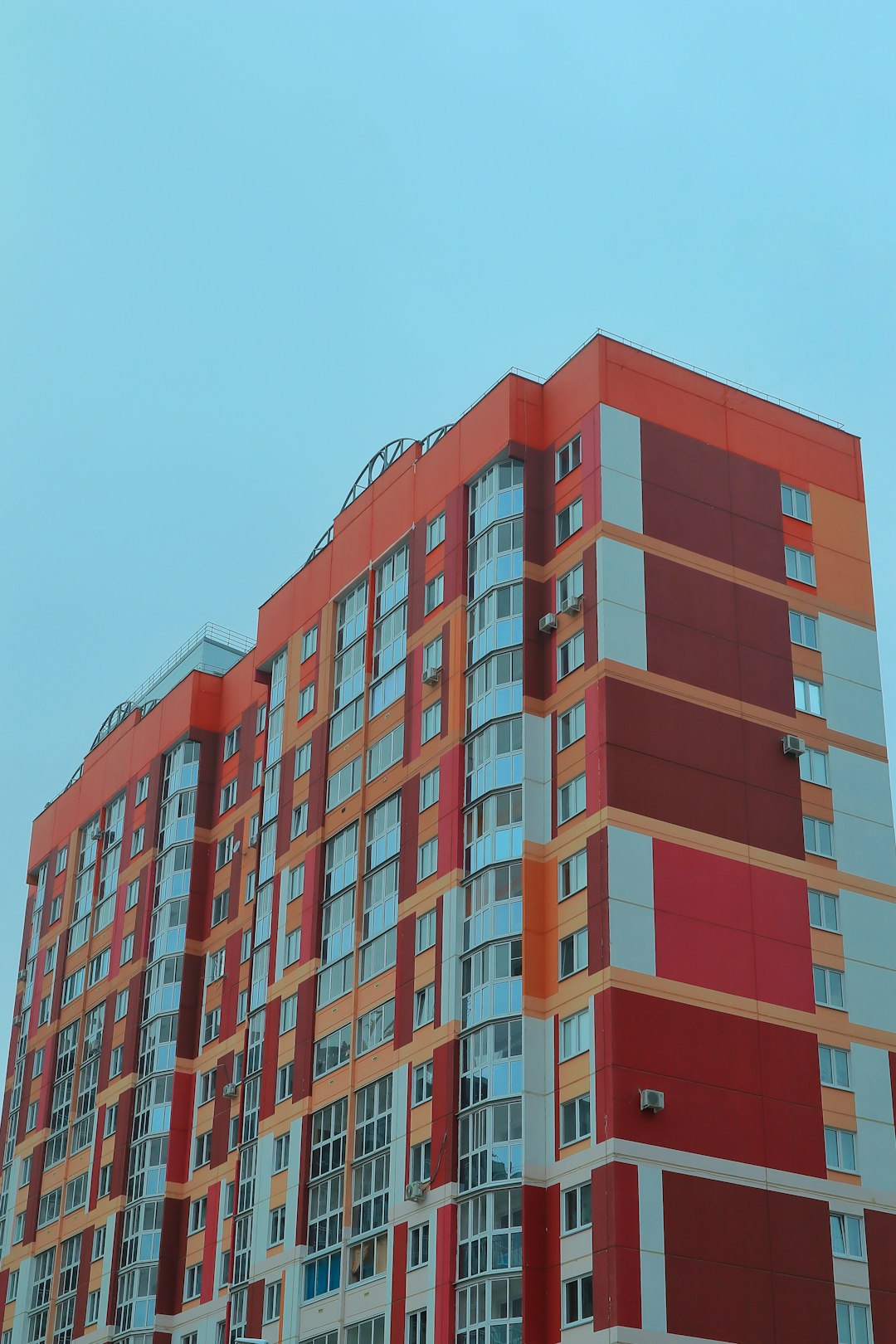 a-tall-red-and-white-building-next-to-a-parking-lot-061lsh9lxrs